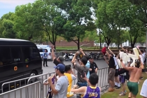 詹姆斯乘车离开交大校园 男球迷赤膊高举King字牌一路狂奔追随